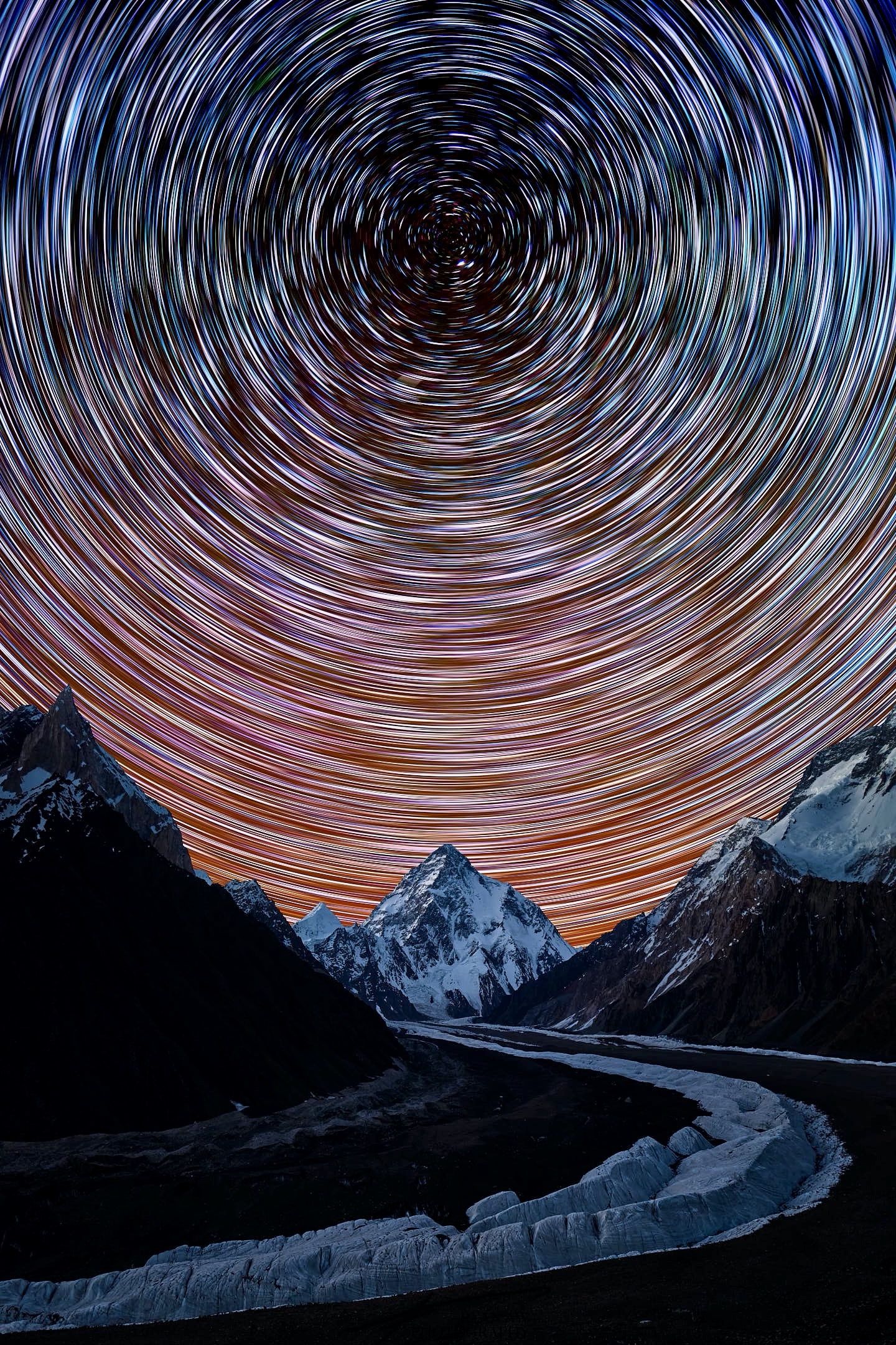 A star trail composite image of the Earth rotating through the universe, aligned almost perfectly with the tip of K2, the second tallest mountain on Earth