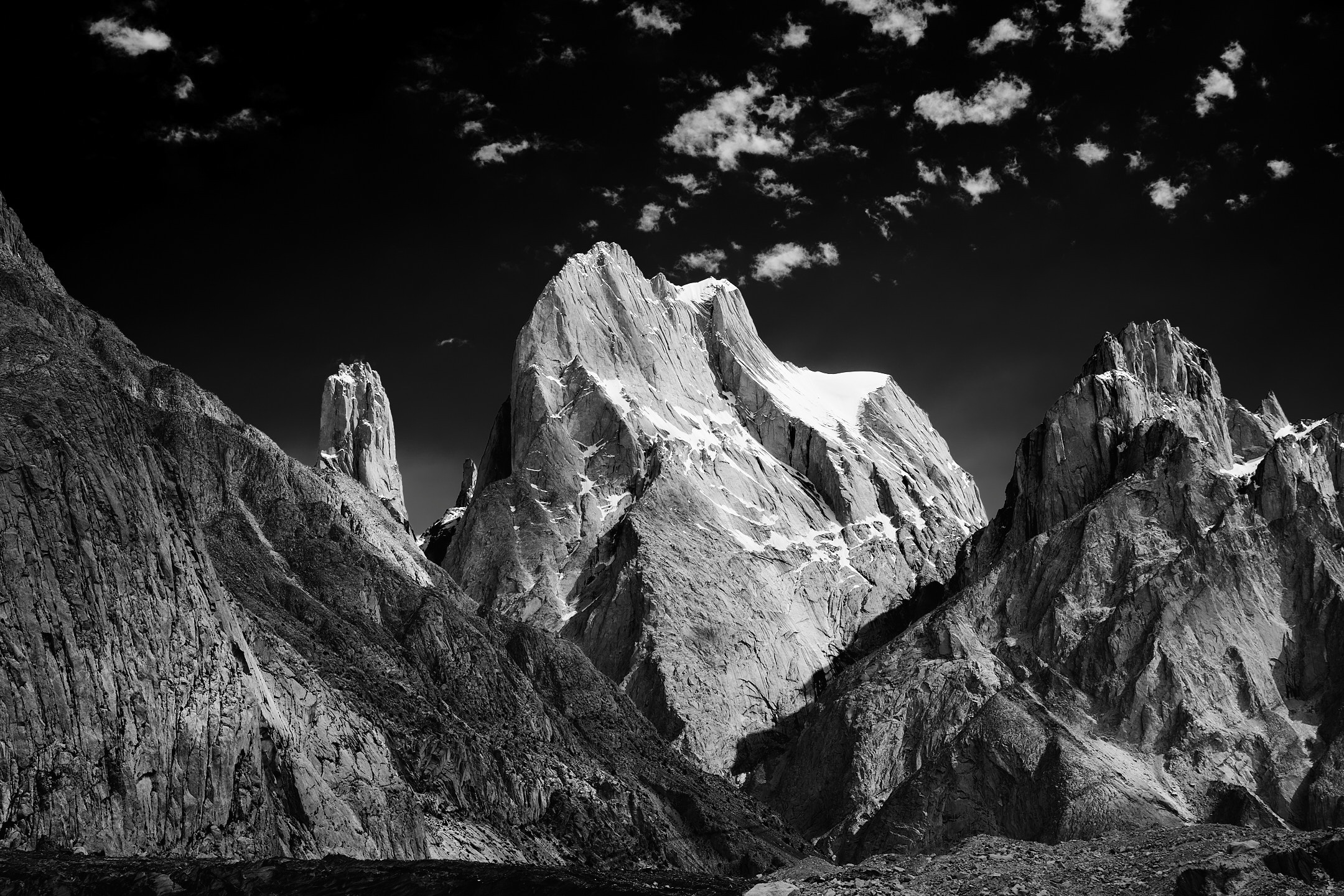 A black and white photo of the infamous Trango Towers complex in the Karakoram mountain range, Pakistan

From left to right:

-Trango II (6237m/20,462ft) 
-Trango Tower/Nameless Tower (6239m/20,469ft) 
-Great Trango Tower (6286m/20,623ft) 
-Trango Pulpit (6050m/19,849ft) 
-Trango Castle (5753m/18,874ft) 